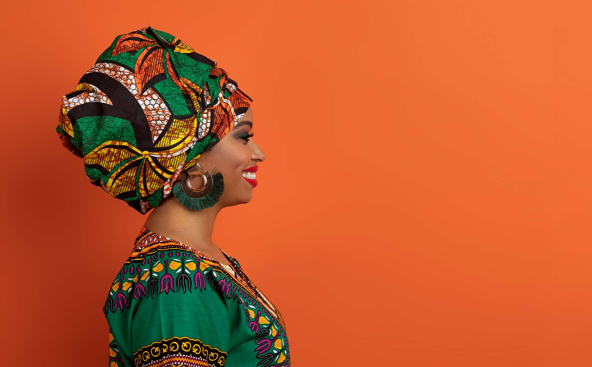 Afrički paterni u dizajnu Tradicionalna nošnja nekih afričkih plemena oslikana afričkim paternima na mladoj i nasmejanoj Afrikanki.